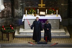 Vicars Lucas Ludewig, left, and Ulrike Garve, right, celebrate a Star Wars themed church service, at the Zion Church in Berlin, Sunday, Dec. 20, 2015. About 500 people, some carrying light saber props or wearing Darth Vader masks, attended the service, more than twice as many as usual on a Sunday. (AP Photo/Markus Schreiber)